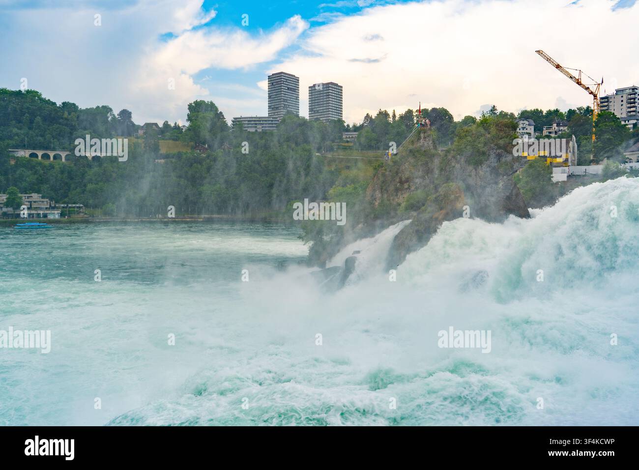 Cascata del Reno con acqua che scende rapidamente e skyline cittadina a Neuhausen, Svizzera. Potente torrente del Reno. Foto Stock