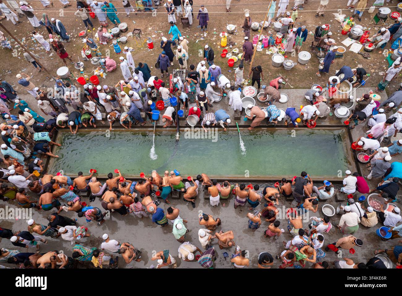 Tongi, Divisione di Dhaka, Bangladesh – 31 gennaio 2025: Vista aerea del Tongi Ijtema Maidan con persone radunate intorno a un serbatoio d’acqua, che si lavano e preparano Foto Stock
