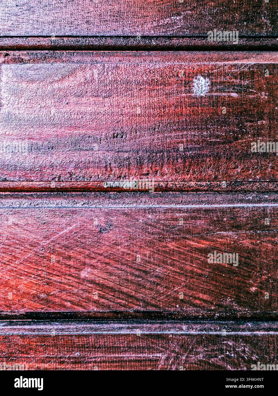 Primo piano di ricche assi di legno marrone scuro e rossastro con venature visibili, graffi e linee orizzontali dei pannelli. - Immagine stock catturata con smartphone