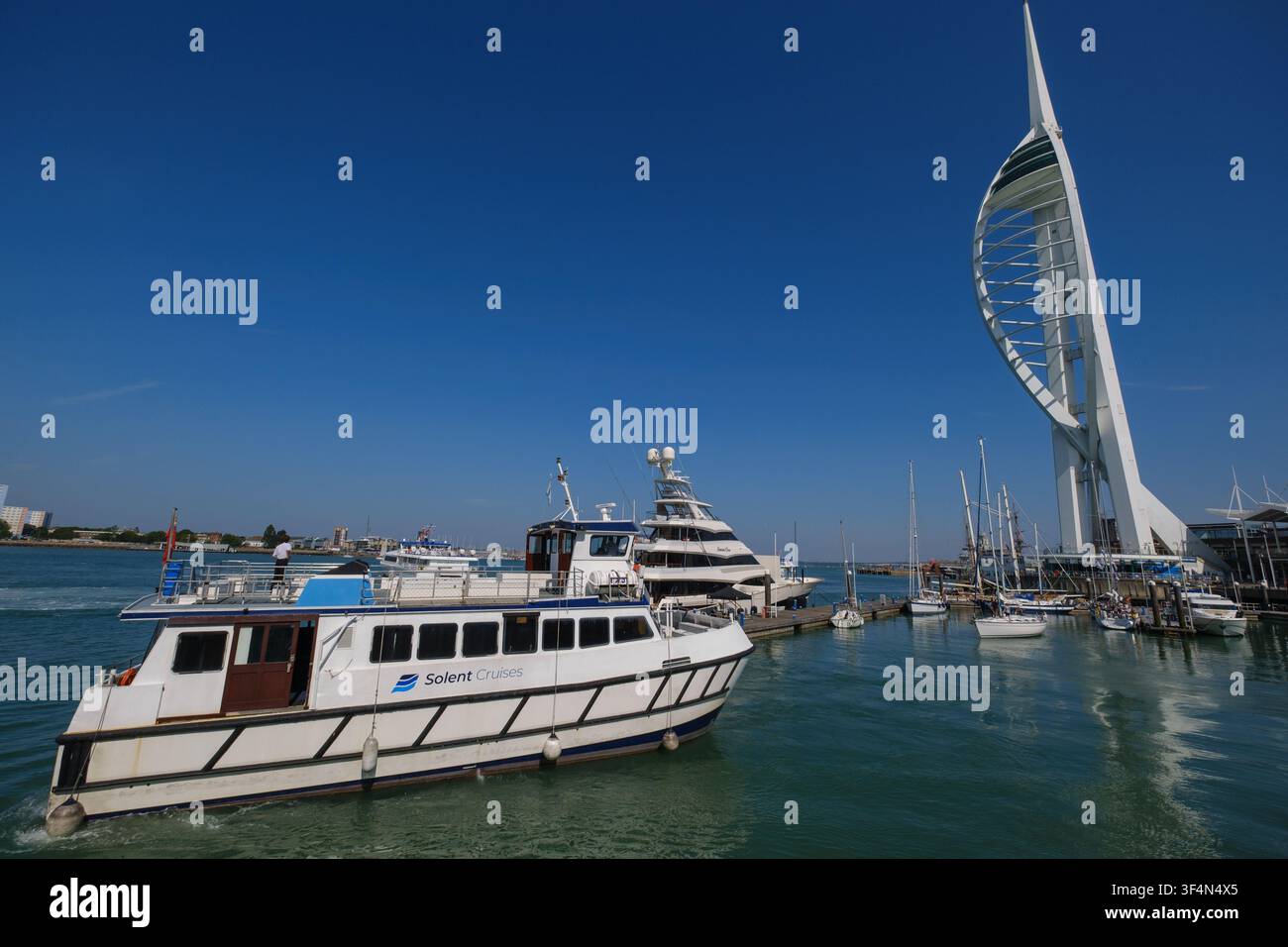 Il catamarano Solent di Solent Cruises arriva all'attracco al Gunwharf Quay di Portsmouth accanto al landmark della Torre Spinnaker. Foto Stock