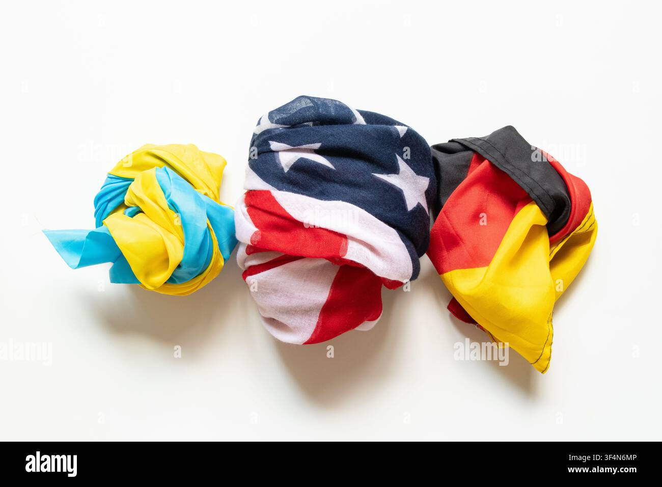 Le bandiere dell'Ucraina, degli Stati Uniti e della Germania sono piegate e disposte su uno sfondo bianco, simboleggiando l'amicizia internazionale, la partnership, Foto Stock