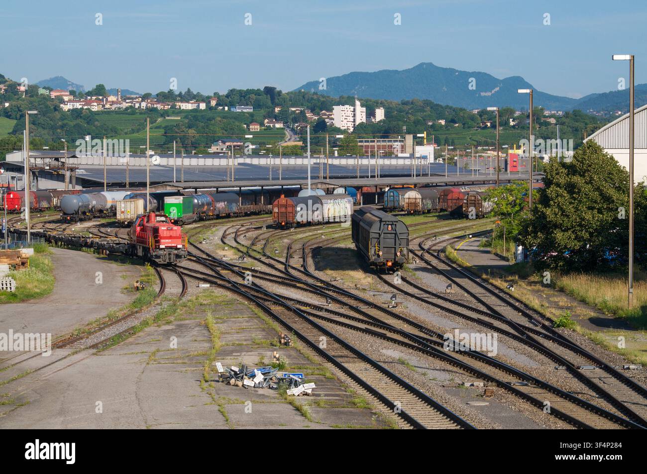Chiasso, Ticino, Svizzera - 17 giugno 2026: Vista di una locomotiva rossa di manovra che si sposta lungo il binario in un grande scalo merci ferroviario Foto Stock