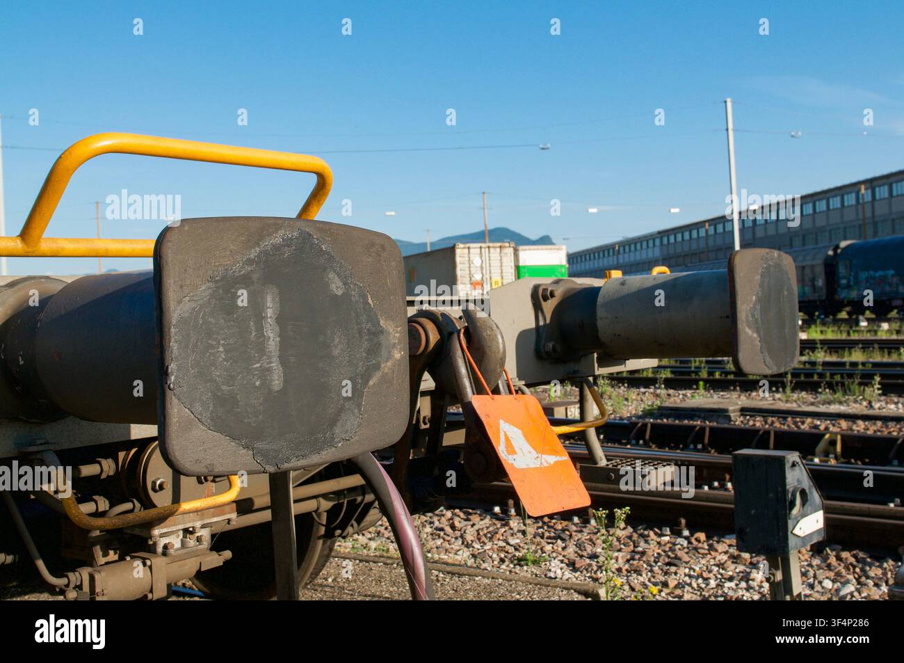 Vista ravvicinata di paraurti in acciaio pesanti e sistema di accoppiamento su un vagone merci parcheggiato in un deposito ferroviario. Concetto di tecnologia ferroviaria Foto Stock