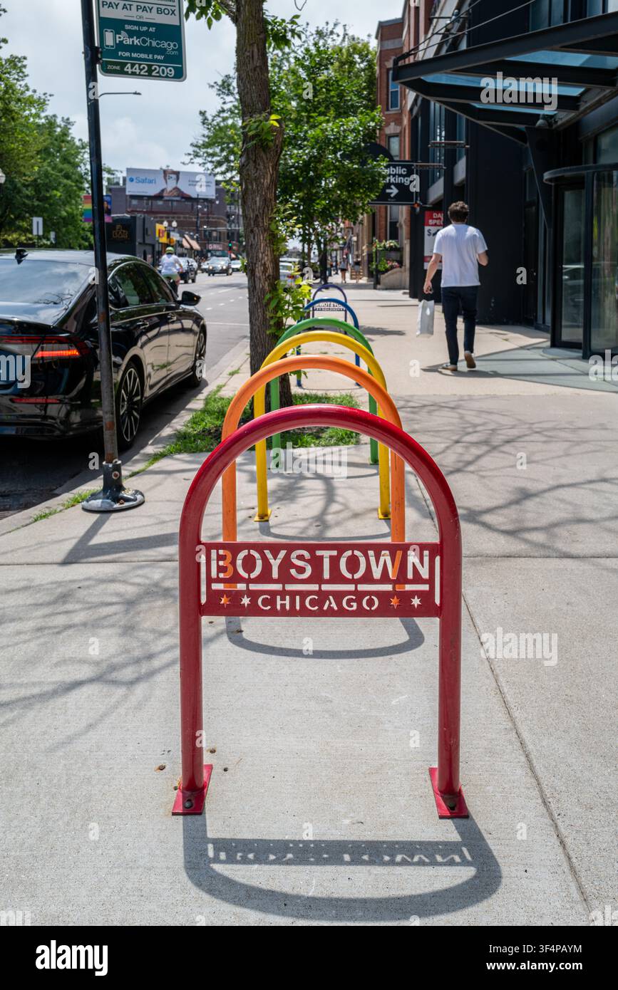 Portabiciclette colorati con supporti arcobaleno che mostrano il marchio Boystown Chicago lungo Halsted Street nel quartiere storico LGBTQ+ di Northalsted. Foto Stock