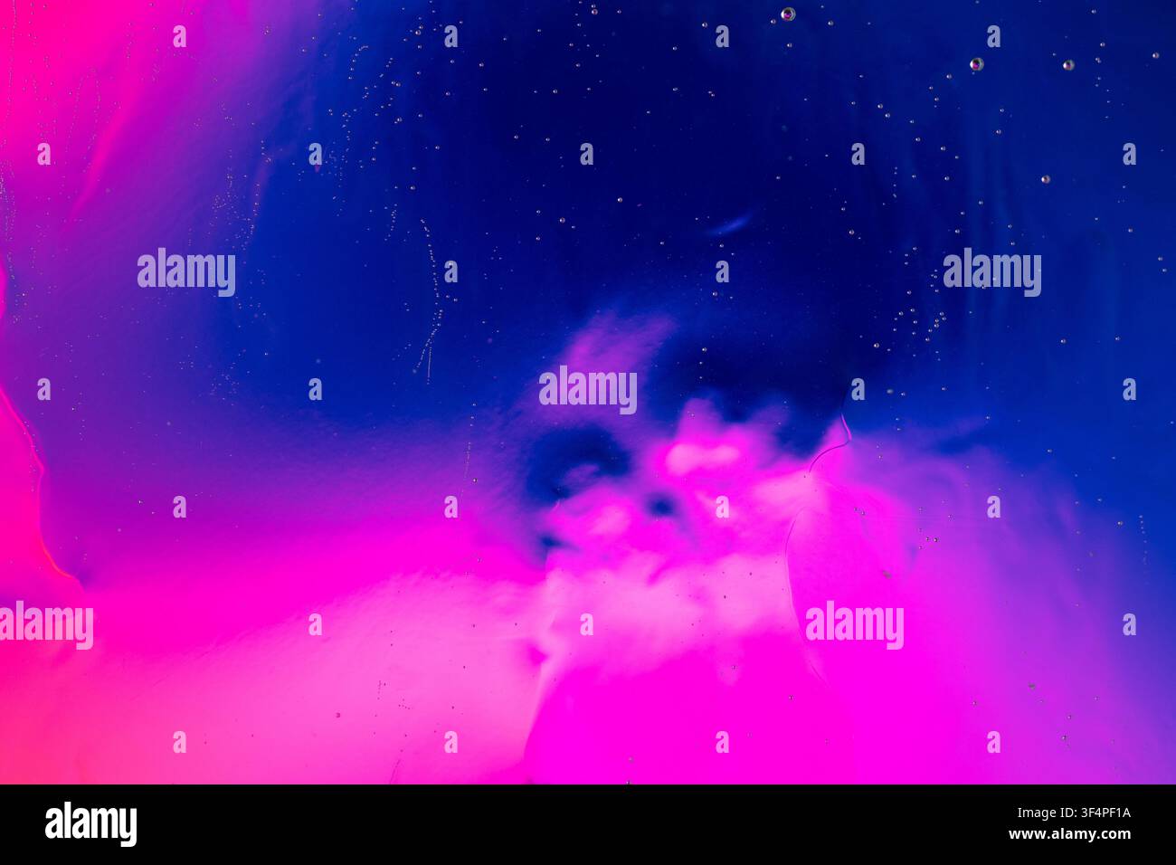 Forme liquide astratte blu e magenta che compongono uno sfondo cosmico vivace con piccole bolle Foto Stock