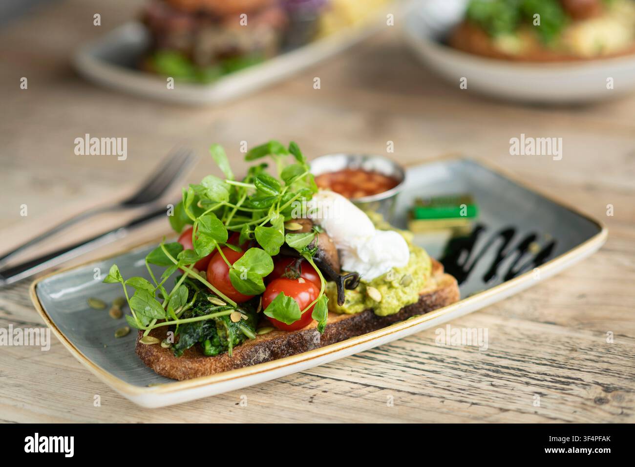 Delizioso panino aperto guarnito con verdure fresche e ingredienti vibranti Foto Stock