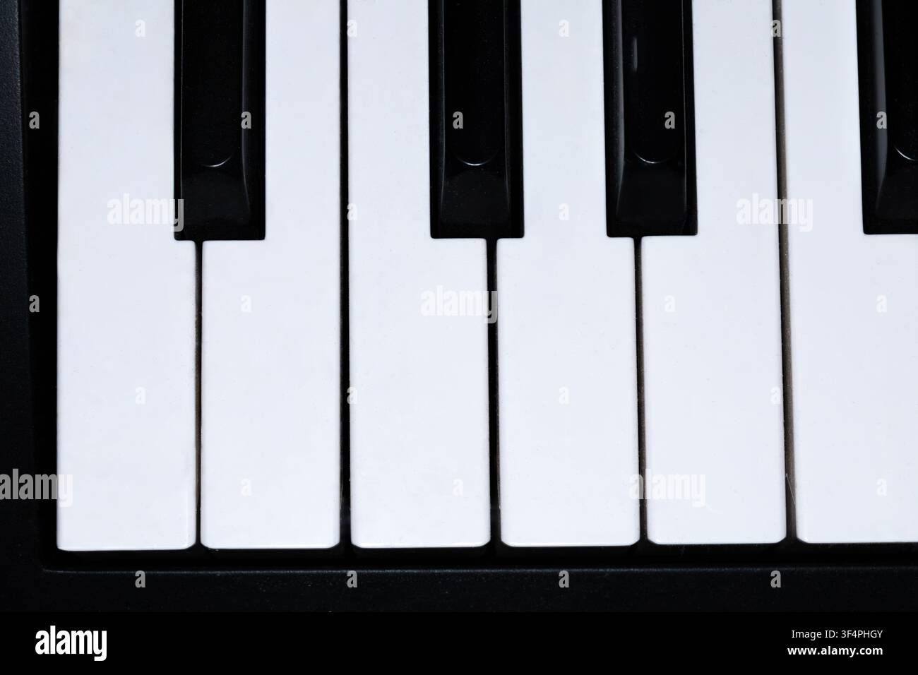 Prima vista delle tastiere bianche e nere di un pianoforte che mostrano un classico schema di tastiera musicale. Ideale per concetti di musica, educazione e strumenti. Foto Stock