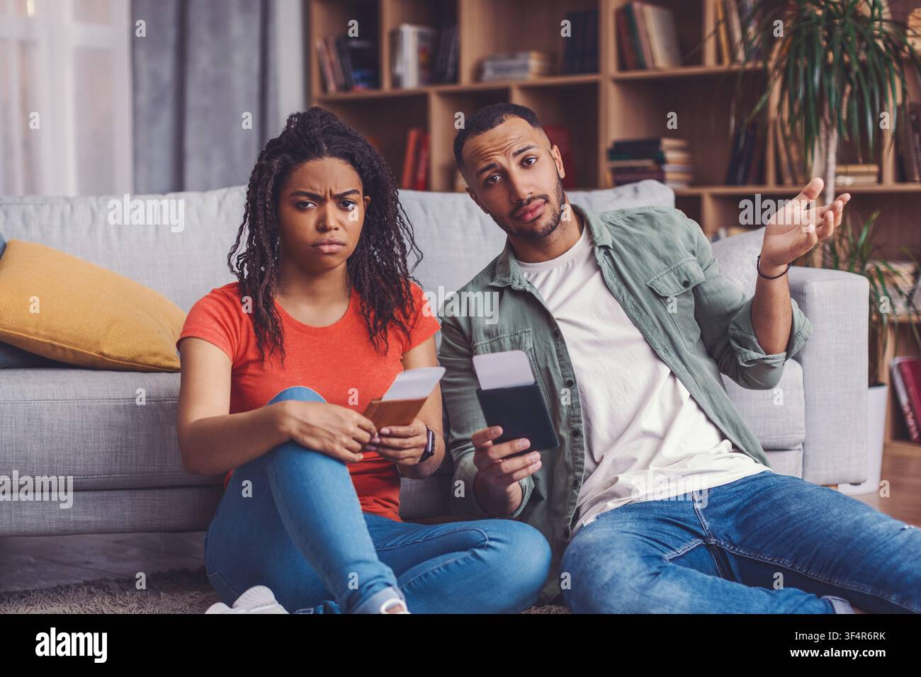 Donna e uomo neri preoccupati che discutono di questioni finanziarie a casa, situazione seria Foto Stock