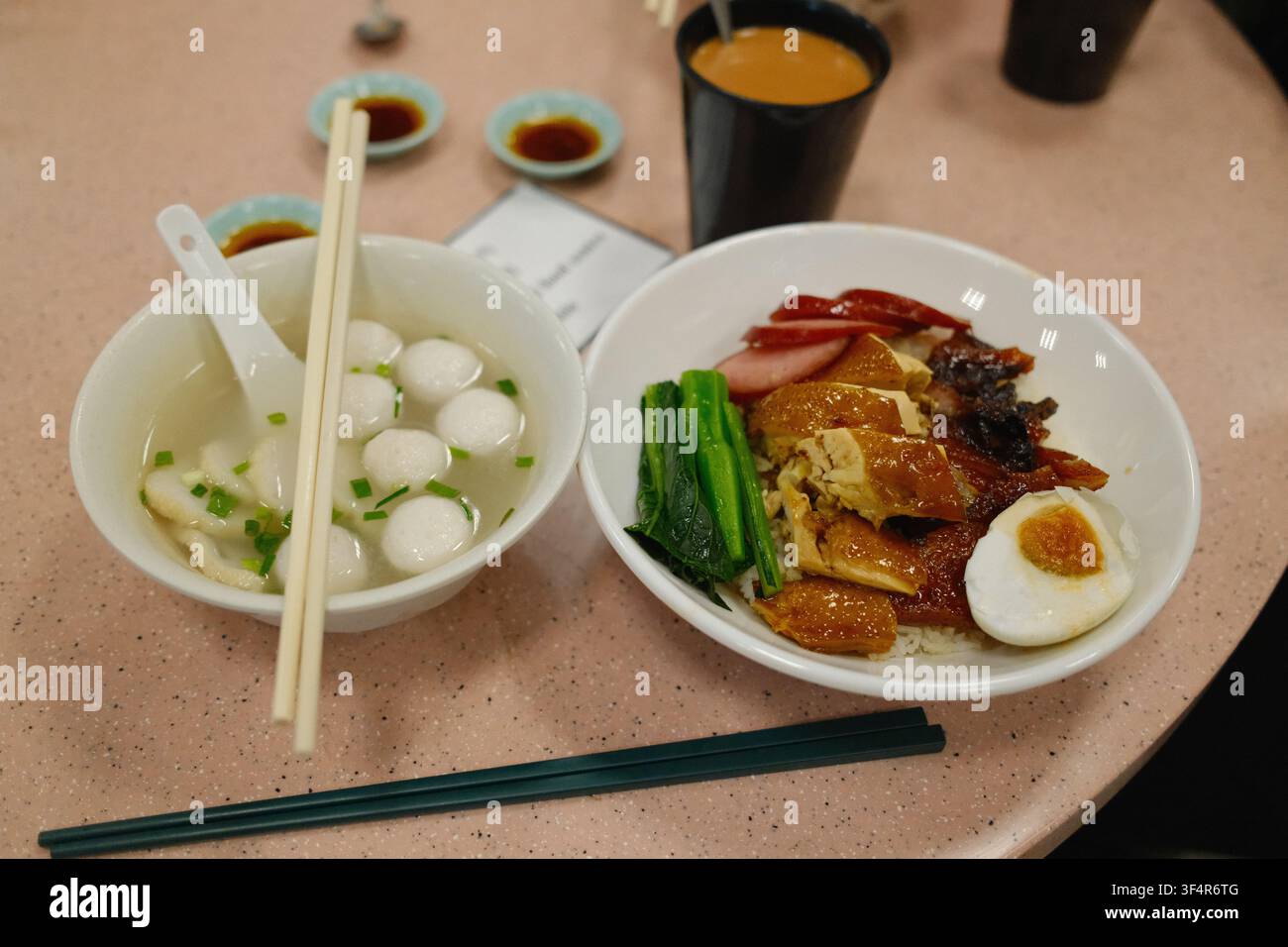 Un classico pasto cantonese con palline di pesce e un piatto di carni arrosto Siu Mei tra cui pollo alla salsa di soia, anatra arrosto, maiale Char Siu e uovo salato. Foto Stock