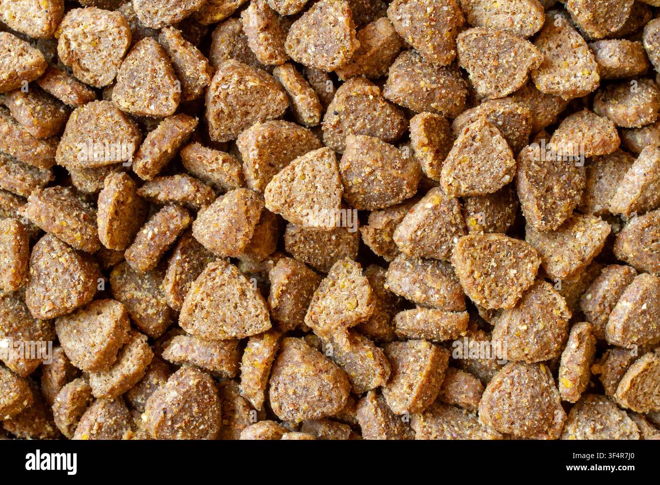 Prima piano di cibo secco per gatti giallo granulato. Textura di cibo secco per animali domestici. Foto Stock