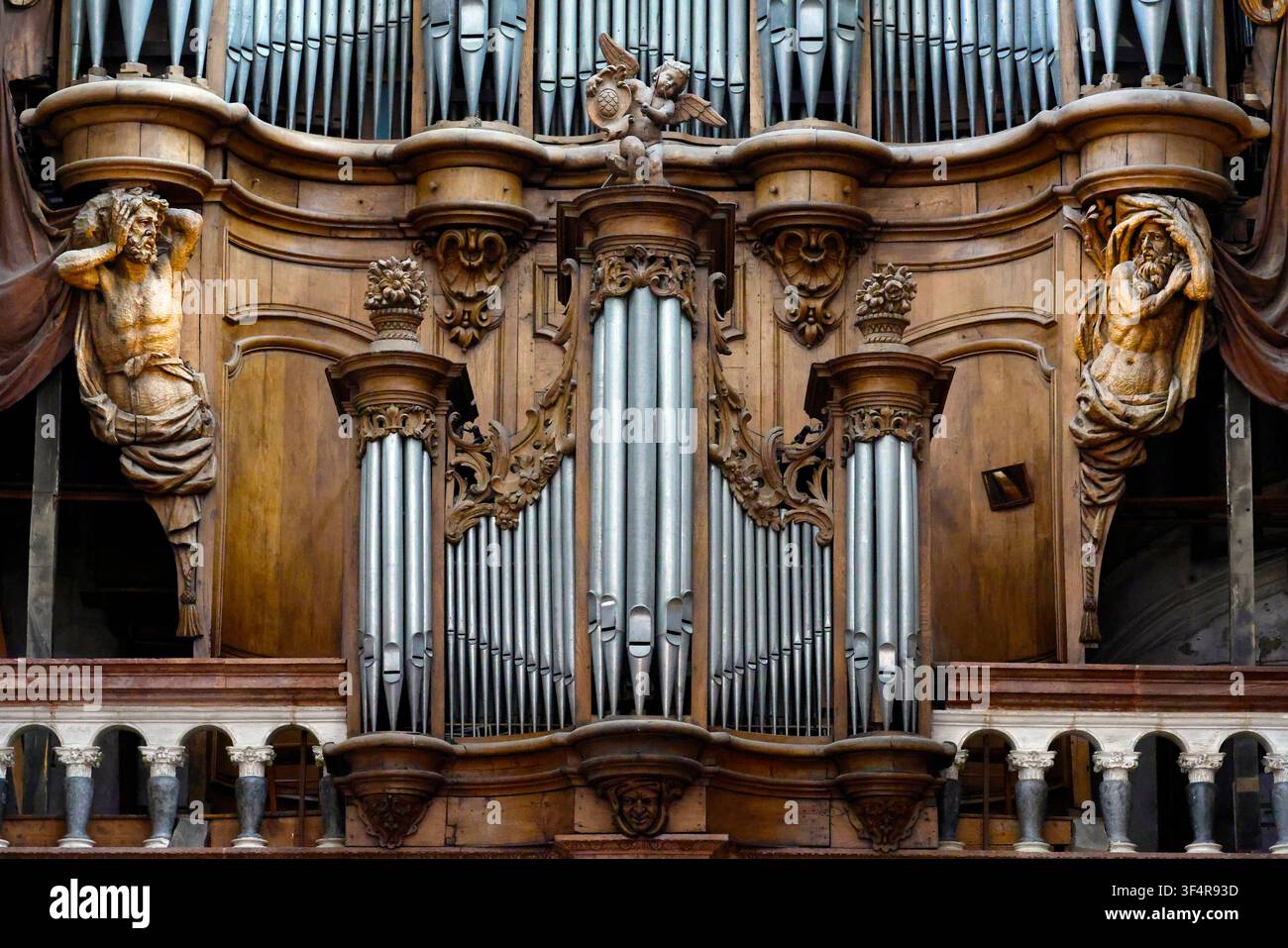 Collegiata di Notre-Dame. Un organo monumentale in legno intagliato con tubi metallici, un cherubino e statue di figure umane. Foto Stock