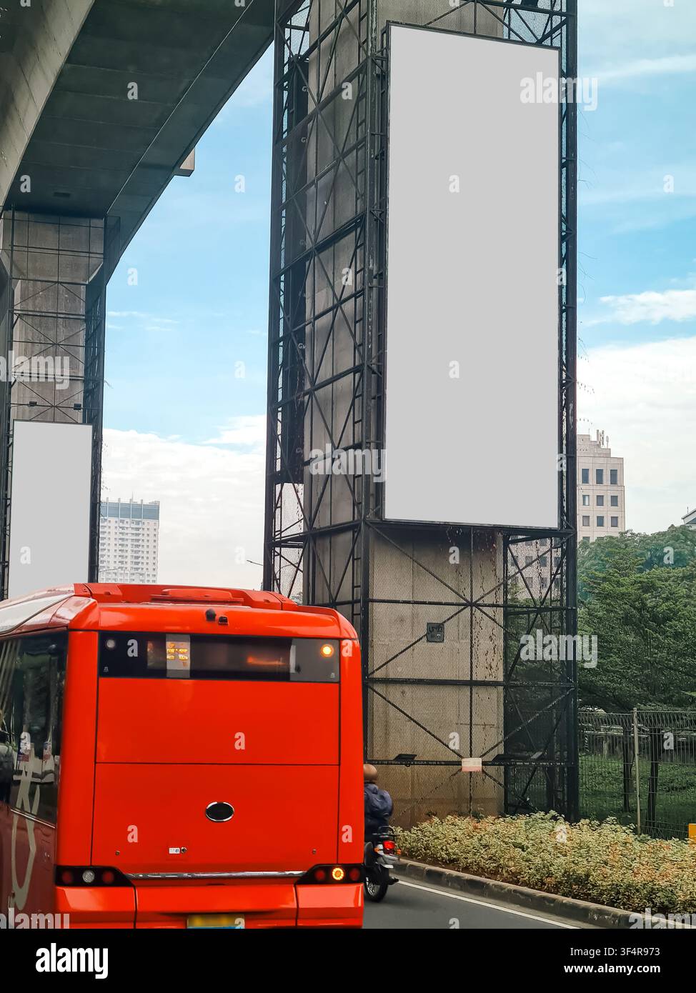 Ampio cartellone pubblicitario verticale vuoto su un pilastro dell'autostrada cittadina con un autobus pubblico rosso in primo piano. Ideale per mockup di media esterni Foto Stock