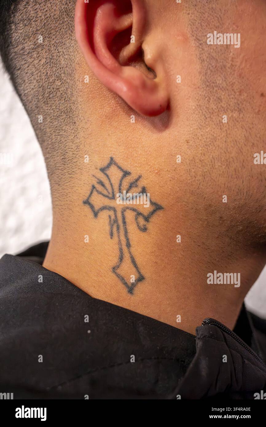 Châtenay-Malabry, Hauts-de-Seine, Francia. Un tatuaggio a forma di croce adorna il collo di un uomo. Il disegno è realizzato con inchiostro nero. Foto Stock