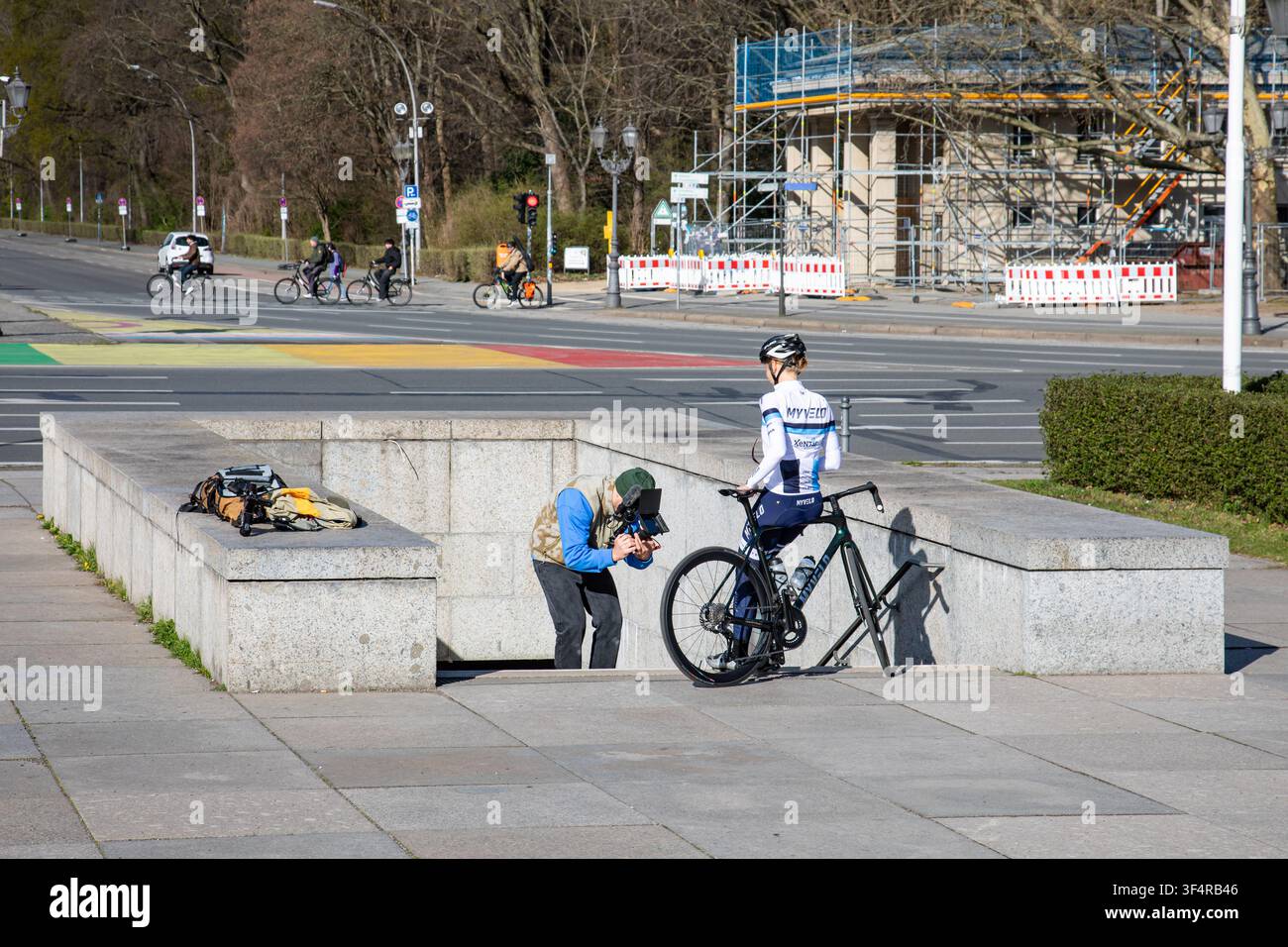 Ciclista su strada femminile filmata o fotografata ai piedi della Colonna della Vittoria a Der Große Stern, Berlino, Germania Foto Stock