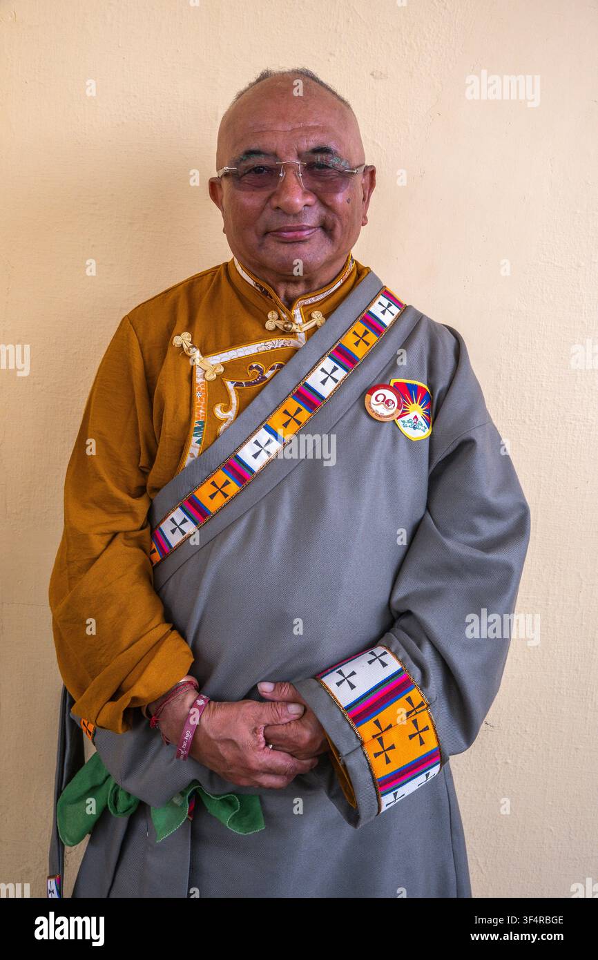 Ritratto di un uomo anziano in abiti tradizionali tibetani, adornato con motivi colorati, durante la Giornata della Rivolta Nazionale Tibetana a Dharamsala, Him Foto Stock