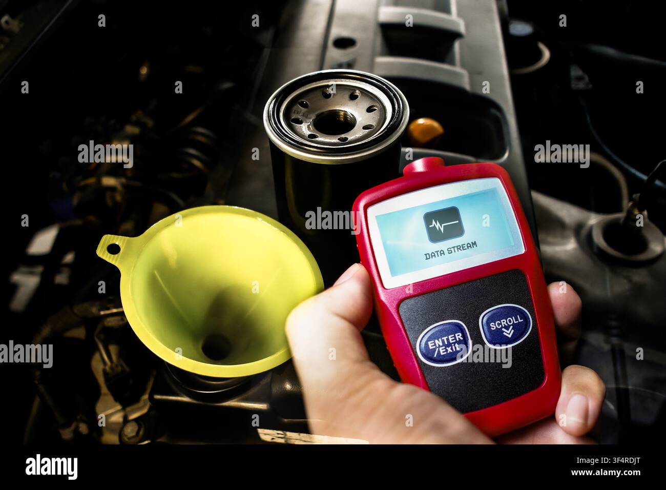 Manutenzione del motore dell'auto con filtro dell'olio, imbuto e scanner diagnostico OBD2 che mostra il flusso di dati per il controllo del veicolo Foto Stock