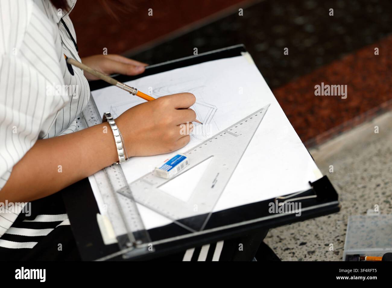 Pagoda Vietnam Quoc Tu. Una persona sta disegnando uno schizzo architettonico su una tavola da disegno, utilizzando una matita, un righello e un quadrato per garantire la precisione. Foto Stock
