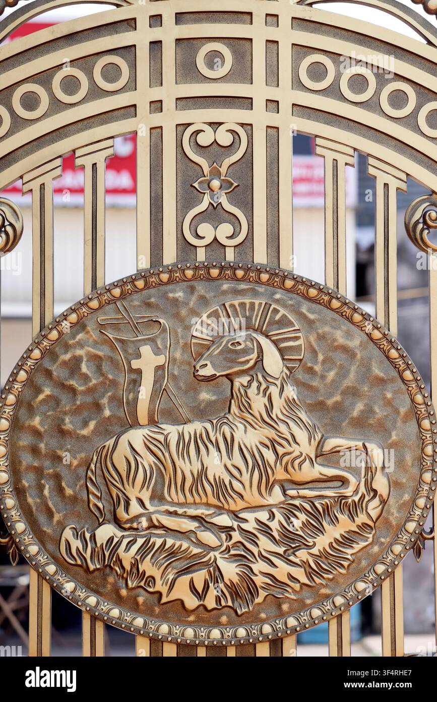 Un cancello adornato con un simbolo cristiano raffigurante l'Agnello di Dio, un simbolo di sacrificio e redenzione. Agnus Dei. Phu Nai. Vietnam. Foto Stock