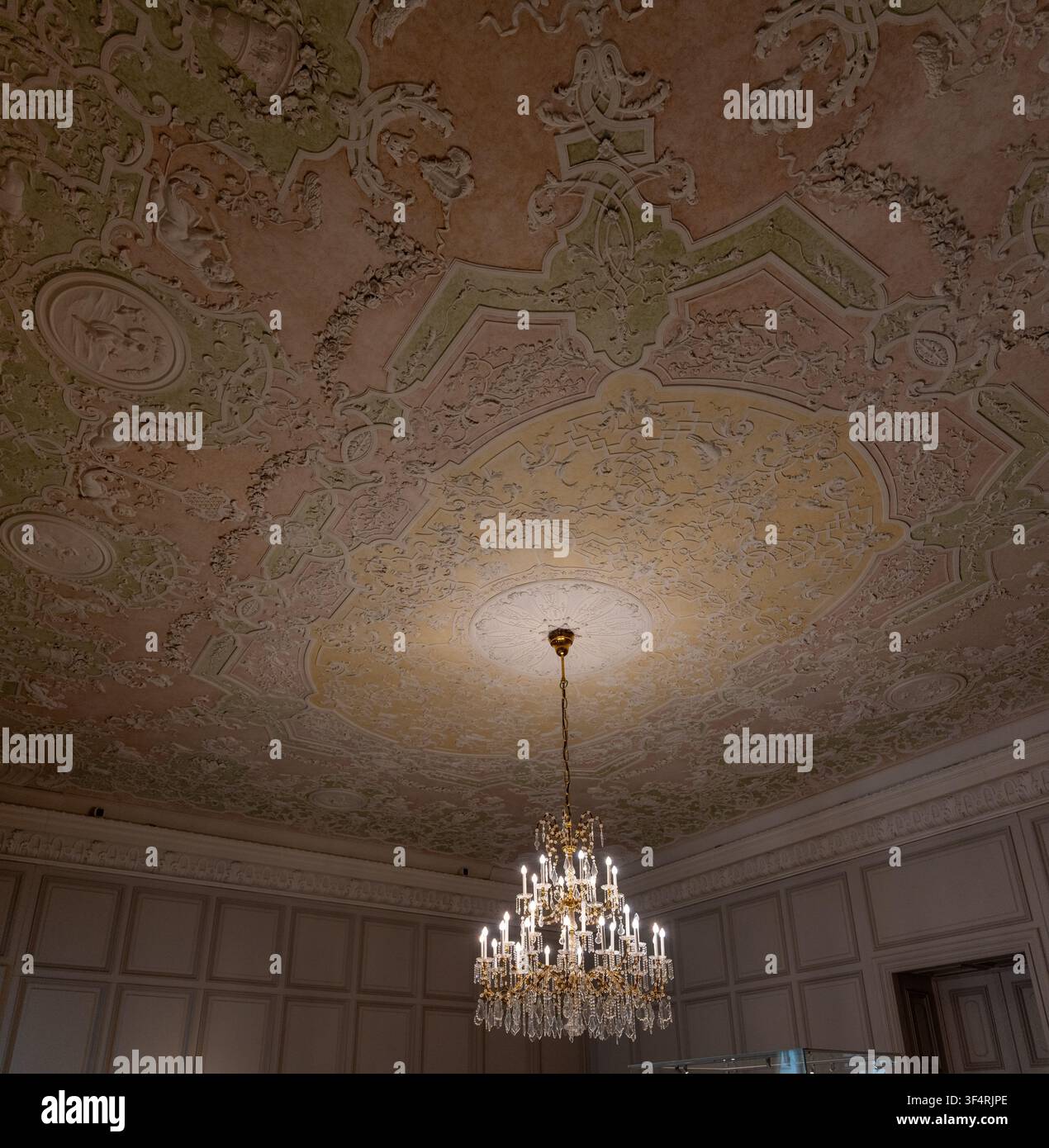 Soffitto rococò decorativo con ornamento in stucco pastello e lampadario di cristallo al Palazzo barocco di Mannheim a Mannheim, Baden-Württemberg, Germania. Foto Stock