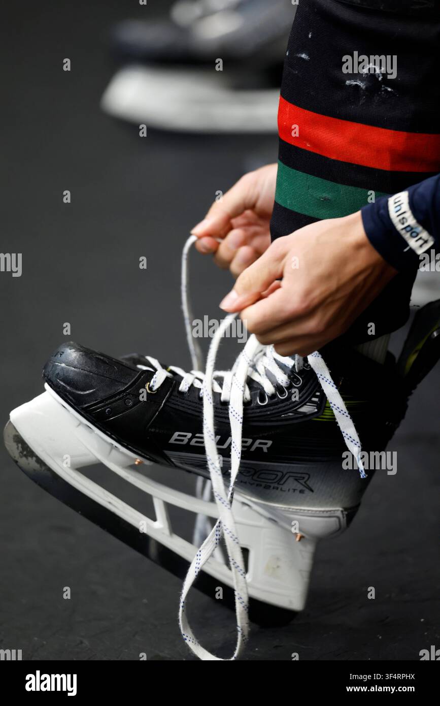 Un giocatore di hockey sul ghiaccio che allaccia il pattino nello spogliatoio prima della partita. Foto Stock