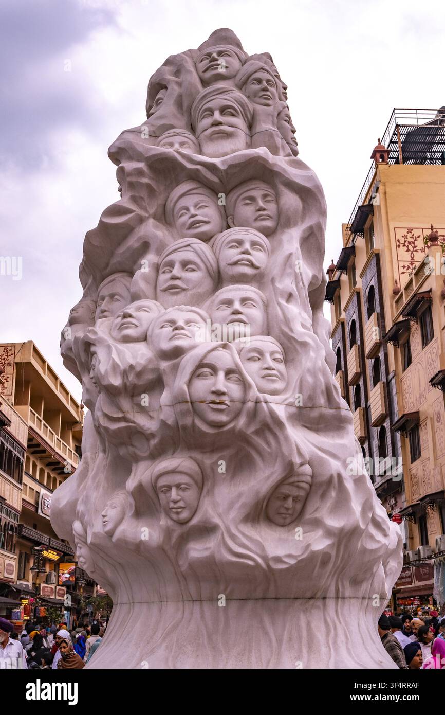 Una scultura monumentale che raffigura numerosi volti si trova a Jallianwala Bagh, Amritsar, India. Questo memoriale commemora un evento storico: il massacro del 1919 Foto Stock