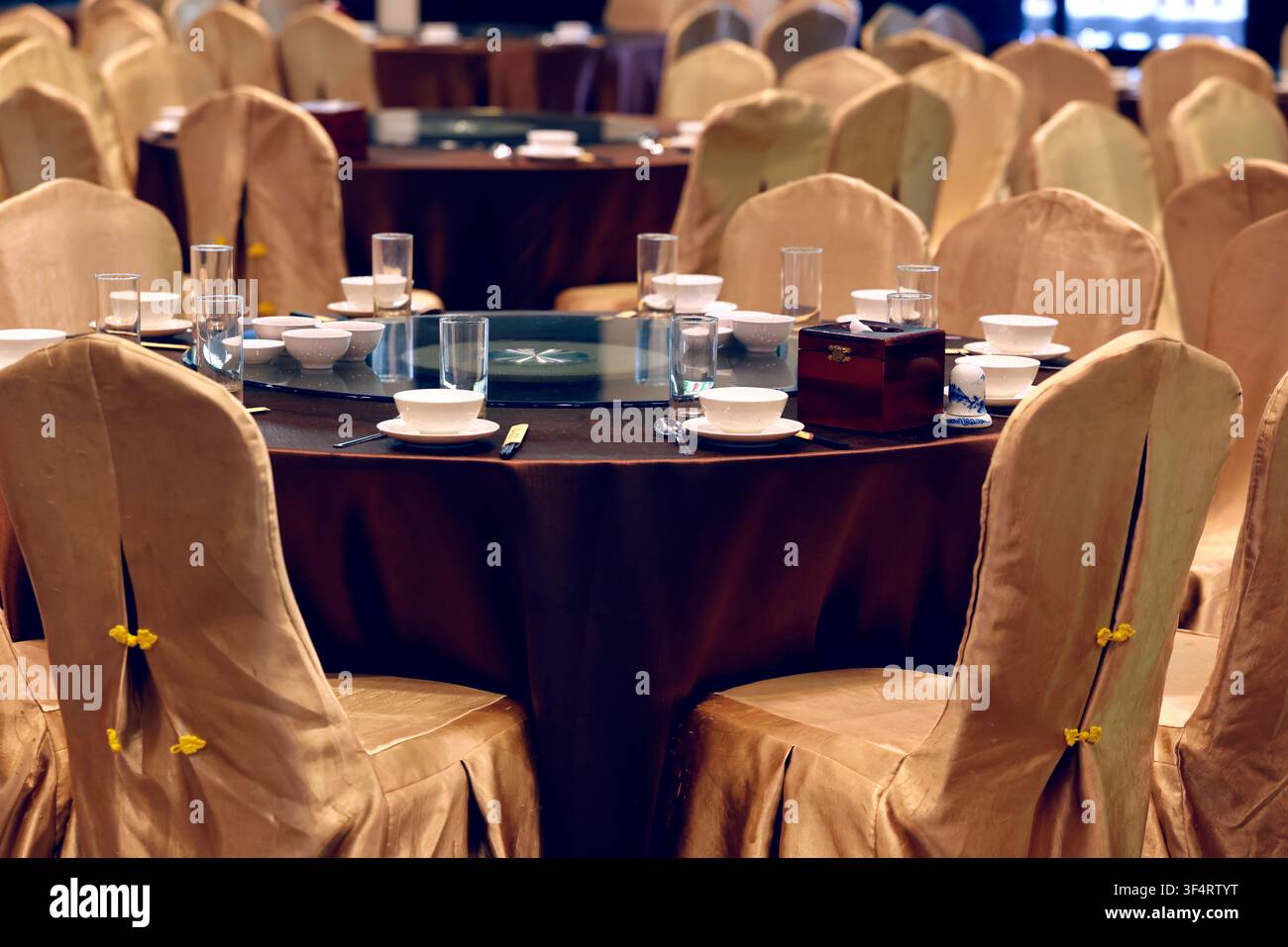 Un tavolo da ristorante è apparecchiato con piatti, bicchieri e posate, pronto per un banchetto o una reception. Hoa Lu, Vietnam. Foto Stock