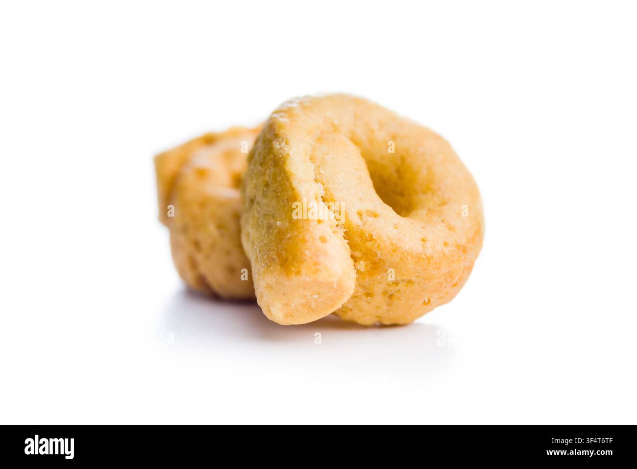 Un primo piano di una pila di taralli dorati, tradizionali cracker italiani a forma di anello, fotografati su sfondo bianco. Spuntino croccante e saporito perfetto per Ap Foto Stock