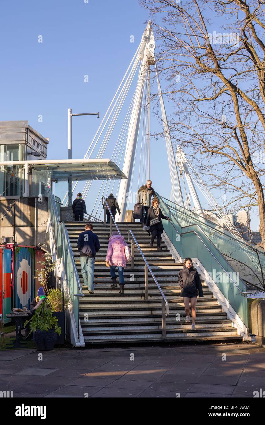 Pedoni che salgono i gradini del Golden Jubilee Bridge dalla South Bank, Londra, Regno Unito. Foto Stock