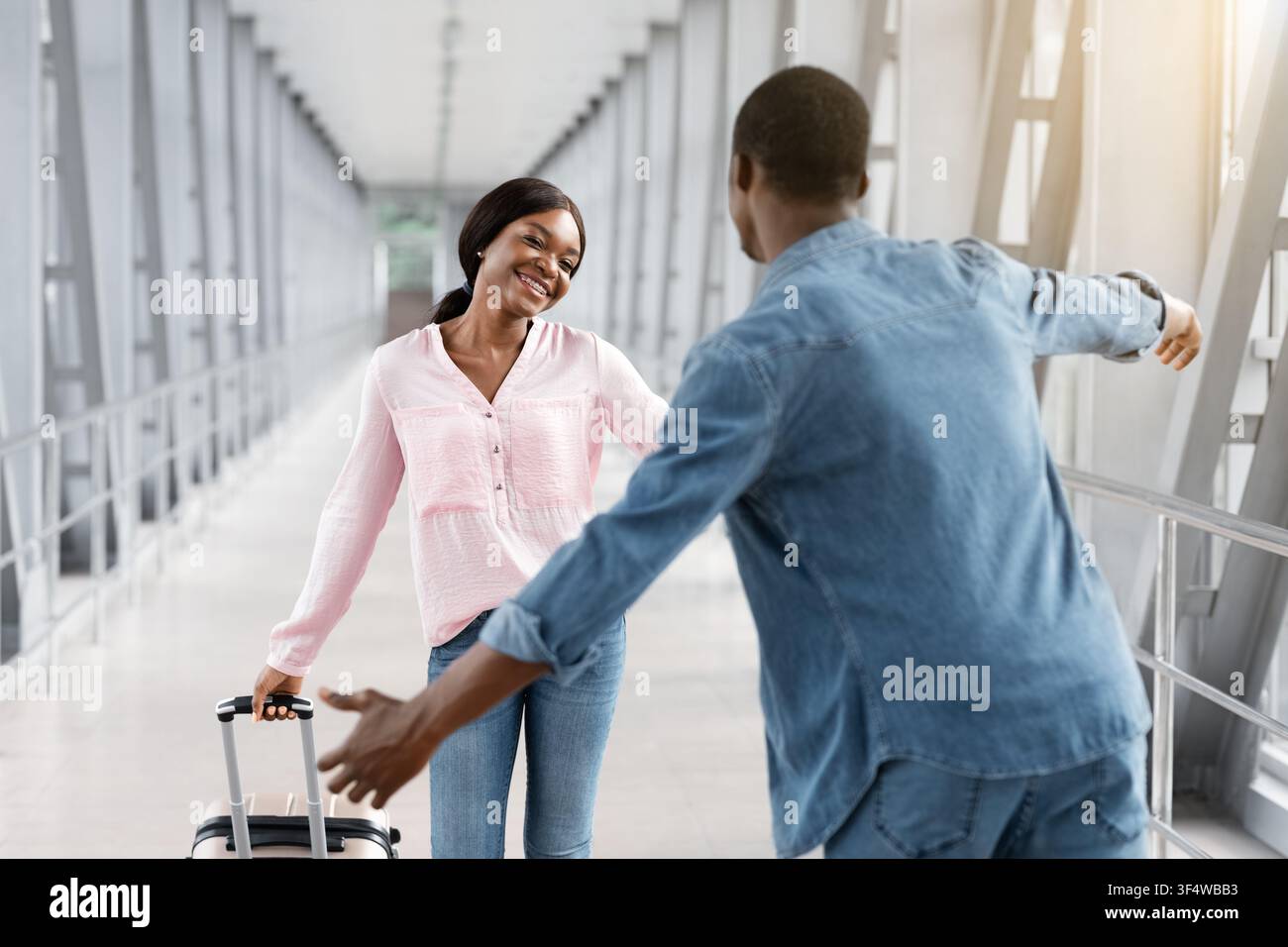Happy African American Woman incontro con il ragazzo al Terminal dell'Aeroporto Dopo l'arrivo Foto Stock
