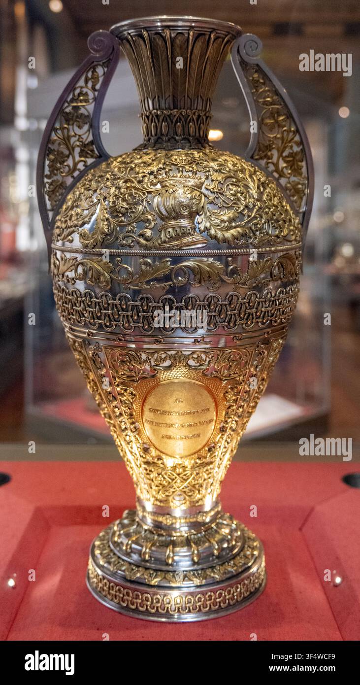 Londra, Regno Unito - 26 giu 25: Vista dettagliata di un vaso cerimoniale dorato elaborato esposto all'interno del Victoria and Albert Museum a Londra. Foto Stock