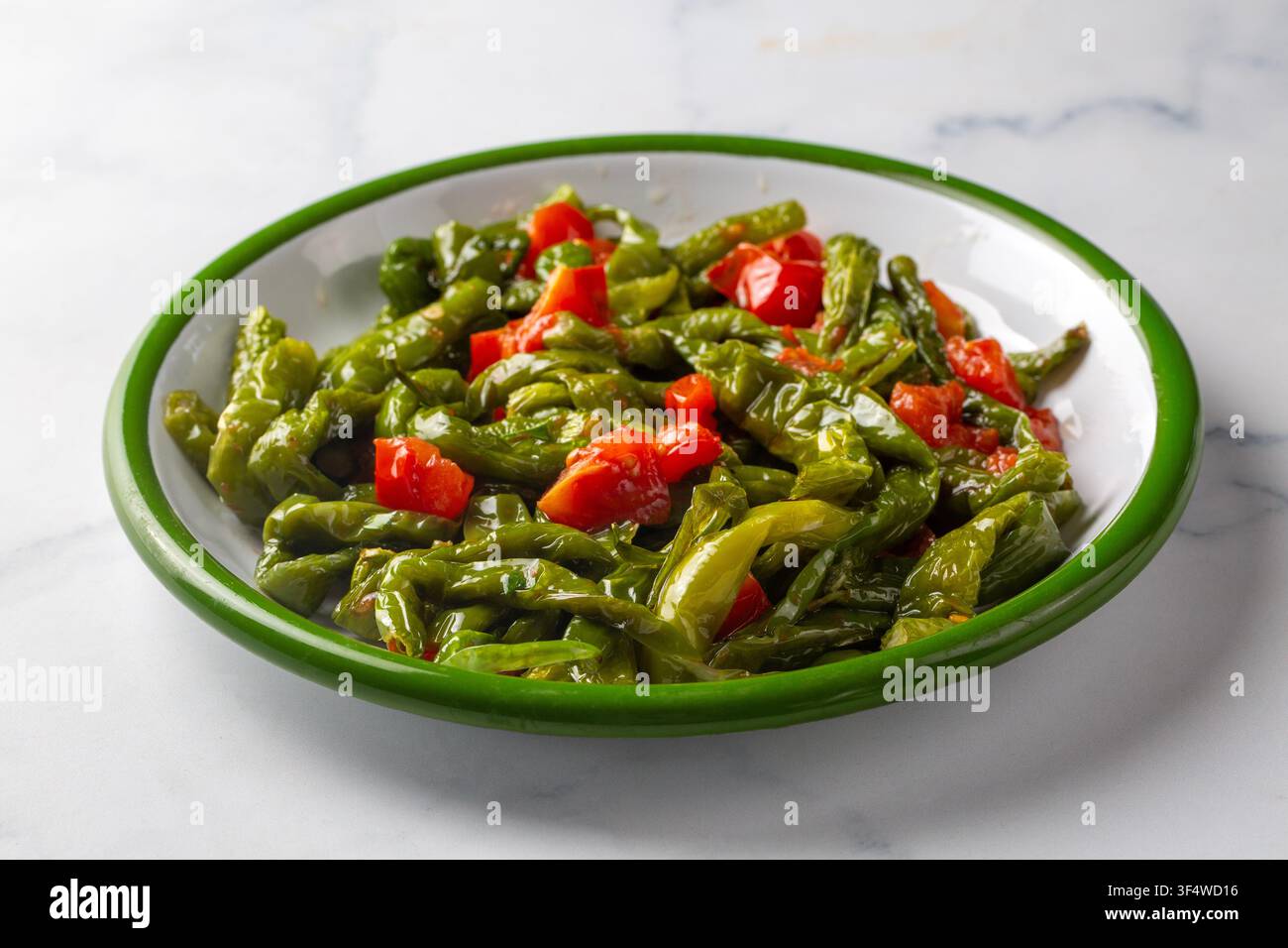 Peperoni verdi friggitello arrostiti e pomodori a dadini serviti - nome turco; Biber kizartmasi Foto Stock