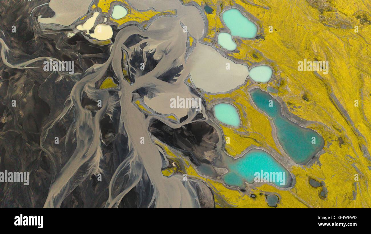 Vista aerea di bacini di acqua di fusione turchese e canali glaciali intrecciati tra muschio e sabbia vulcanica nera a est del ghiacciaio Mýrdalsjökull, in Islanda. Foto Stock