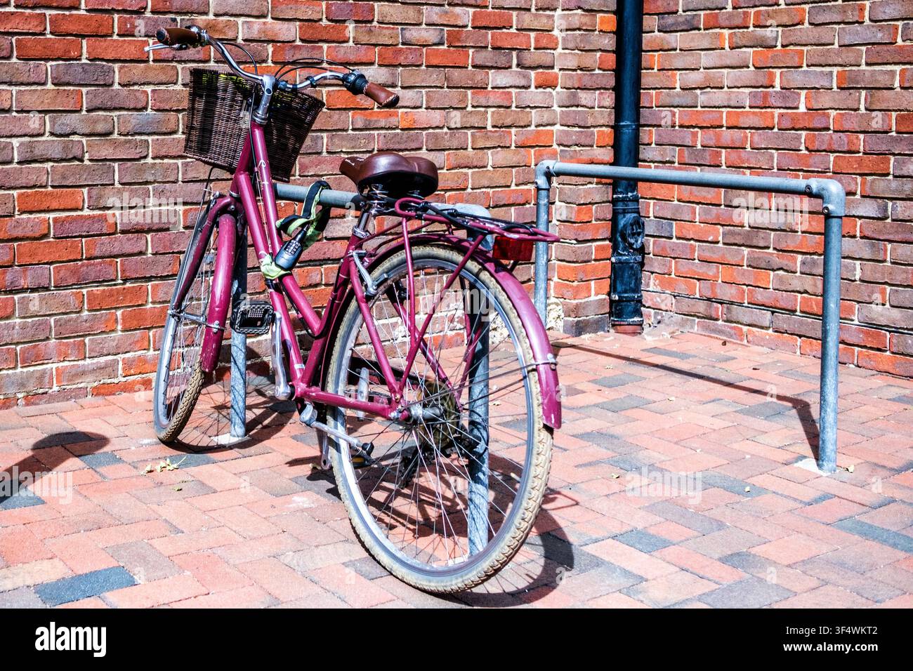 Londra UK, 30 luglio 2026, Un primo piano di una bicicletta vecchio stile fissata saldamente a un supporto per biciclette in metallo con un lucchetto pesante per prevenire il furto Foto Stock