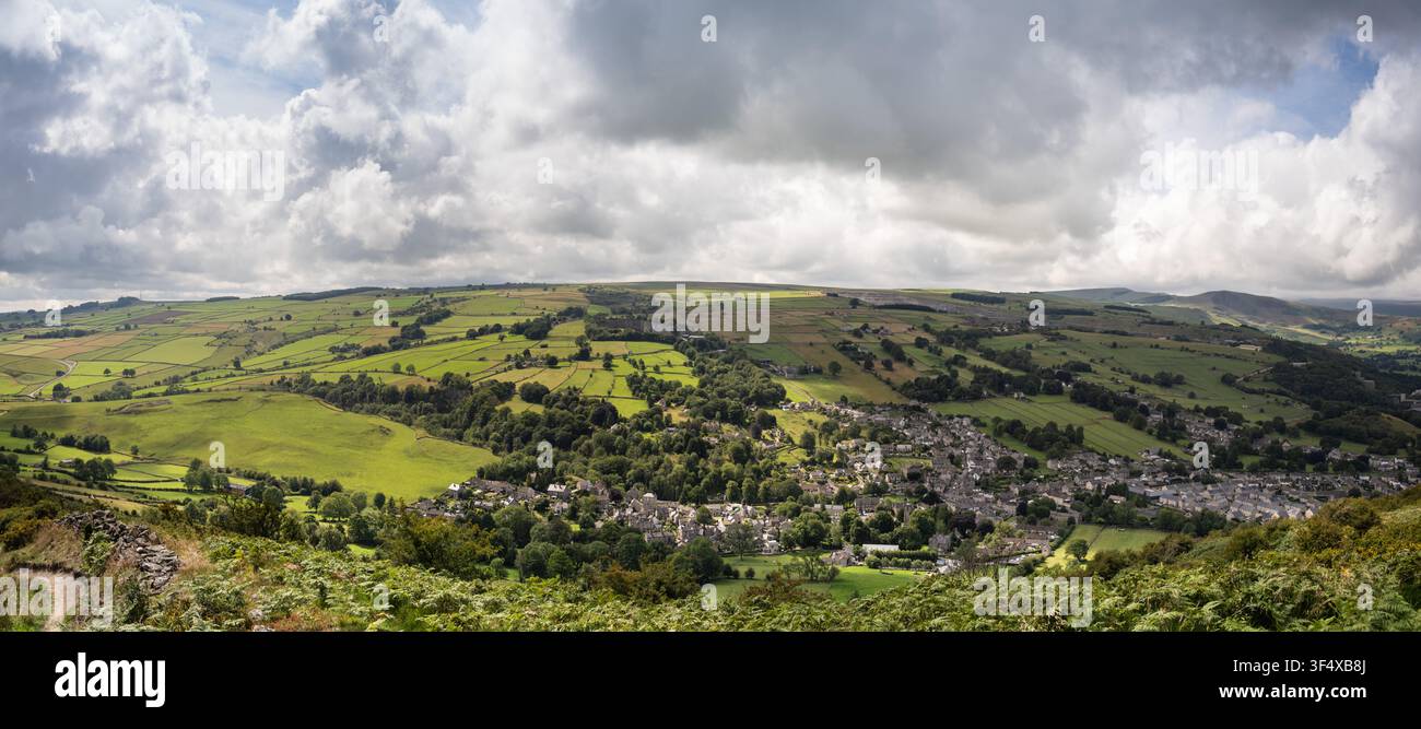 Un panorama ad angolo alto da Bradwell Edge rivela la vasta e pittoresca valle verde, i campi a chiazze e il villaggio sotto un cielo drammatico Foto Stock