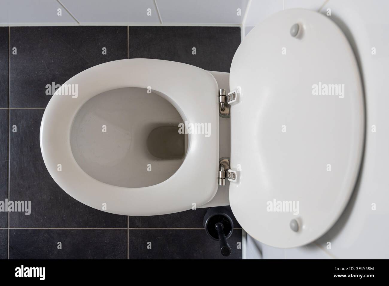 toilette a muro con il coperchio completamente aperto nel bagno Foto Stock