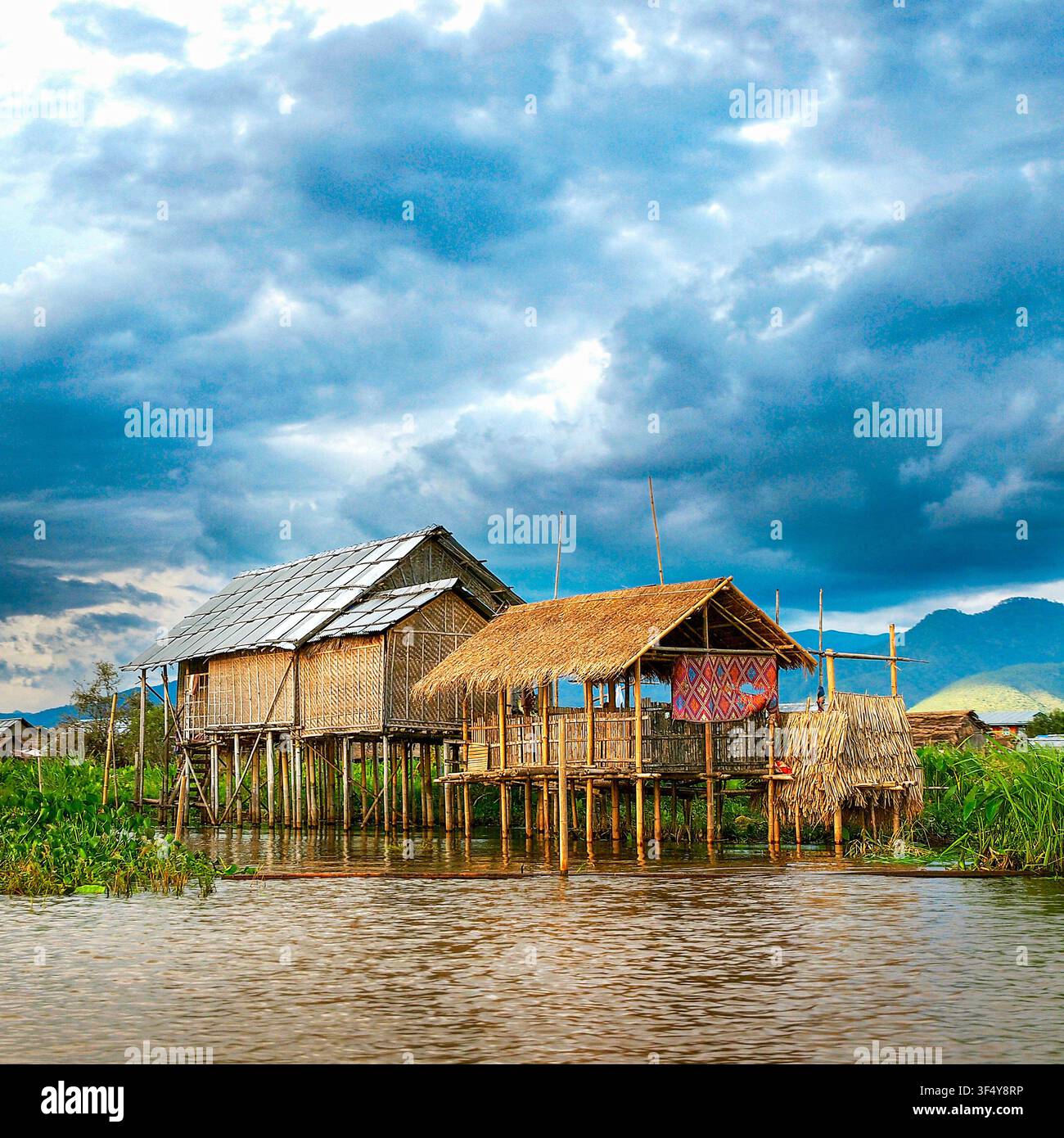 Case tradizionali su palafitte al lago Inle, Myanmar, che mostrano lo stile di vita di un villaggio fluttuante, una vita locale sostenibile e case in legno sopra le acque calme di Shan Foto Stock