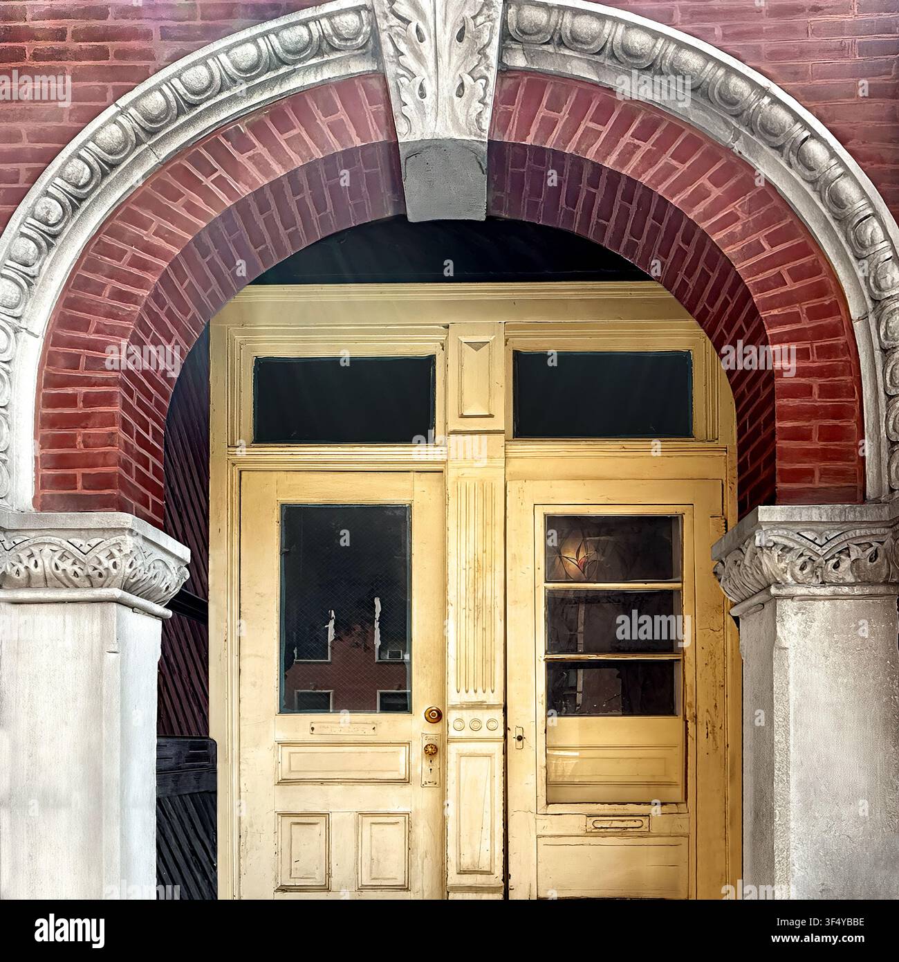 Porte doppie color crema sotto un arco romanico ornato in mattoni e calcare su un edificio storico a Chicago. Foto Stock