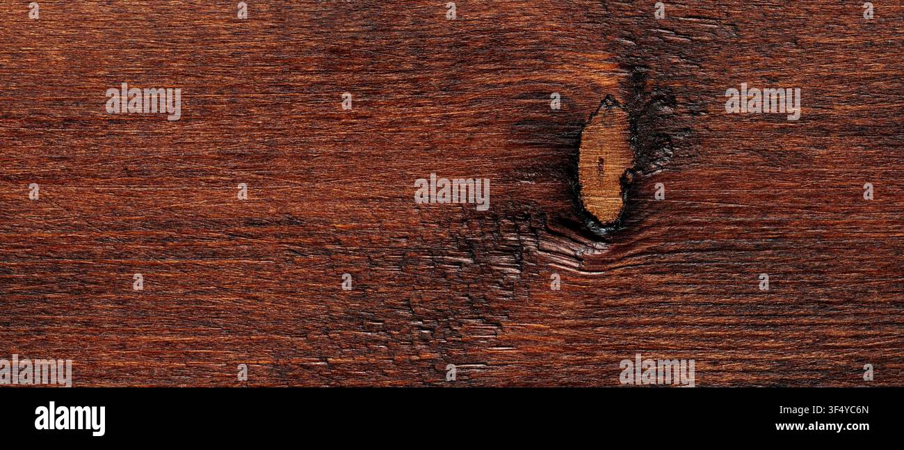 Sfondo in texture di legno marrone rossastro scuro con nodo naturale e motivo di venatura orizzontale Foto Stock