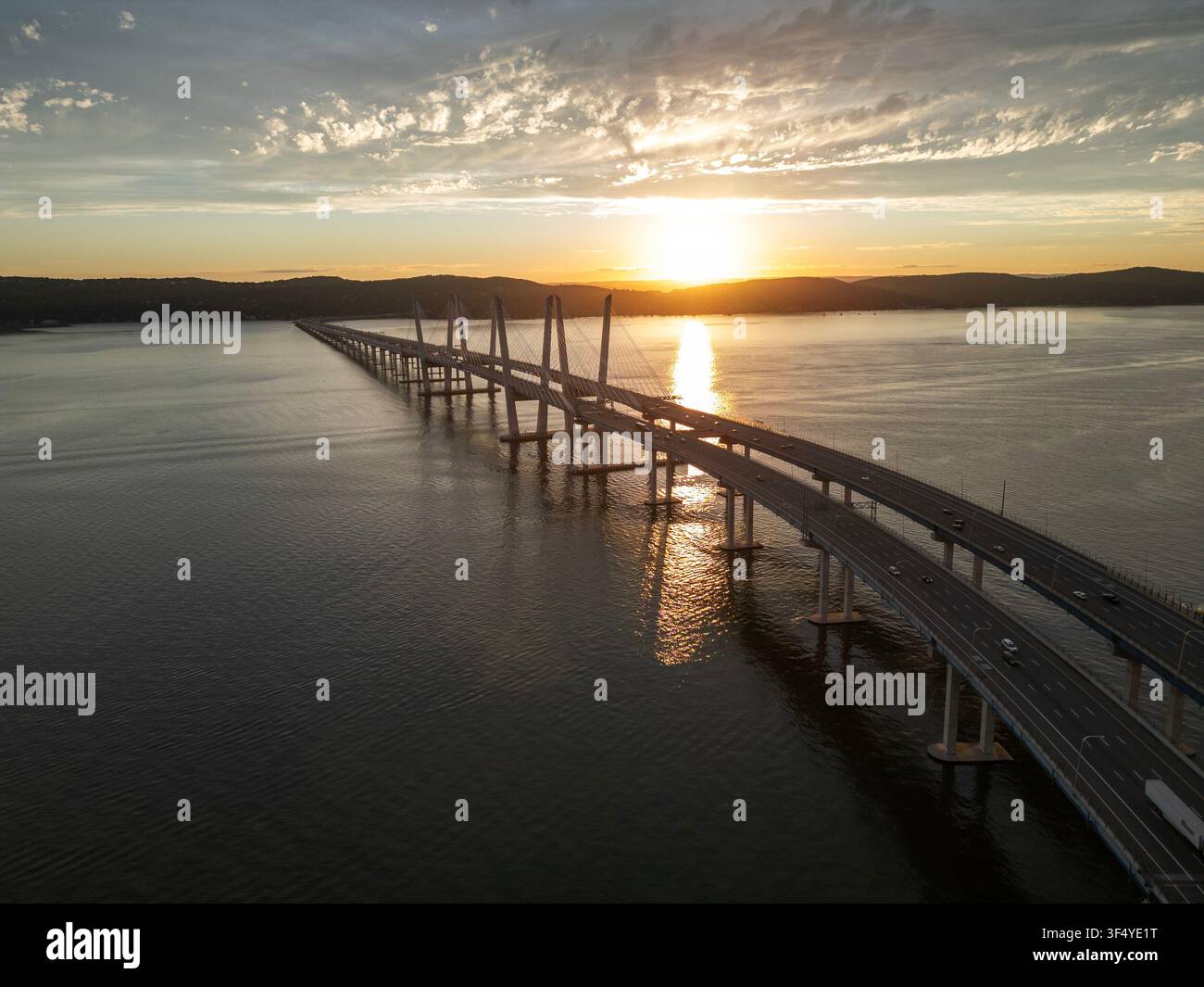 Il sole tramonta dietro il ponte Cuomo e si riflette nel fiume Hudson dall'alto Foto Stock