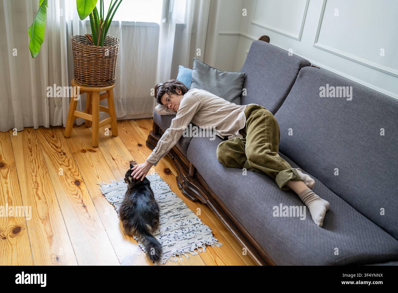 Noia, procrastinazione e pigrizia, donna tranquilla e inattiva che riposa sul divano a casa durante il giorno Foto Stock