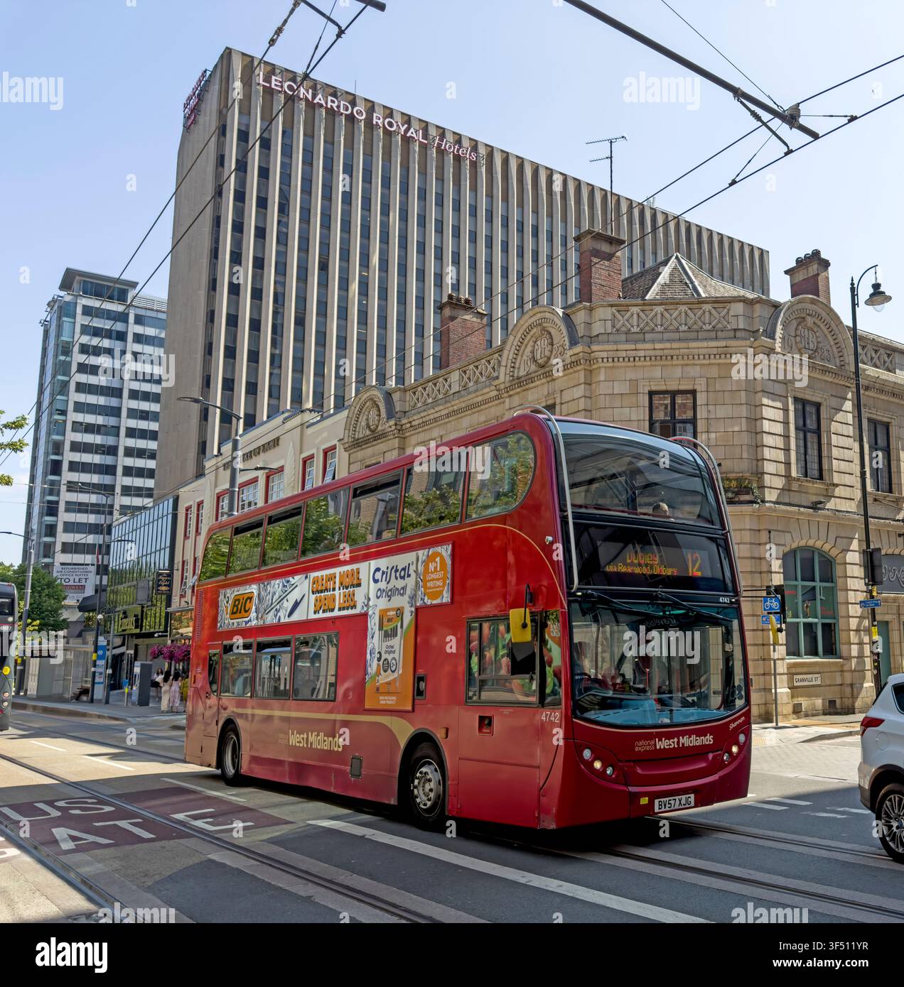 Bus rosso Dudley WM della linea 12 sotto i binari del tram in Broad Street, centro città di Birmingham, le tariffe presto bloccate da Andy Burnham a £2 Foto Stock