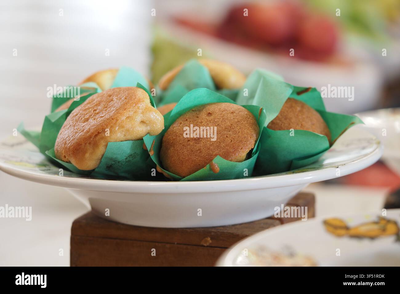 Muffin appena sfornati su un piatto con involucri verdi Foto Stock