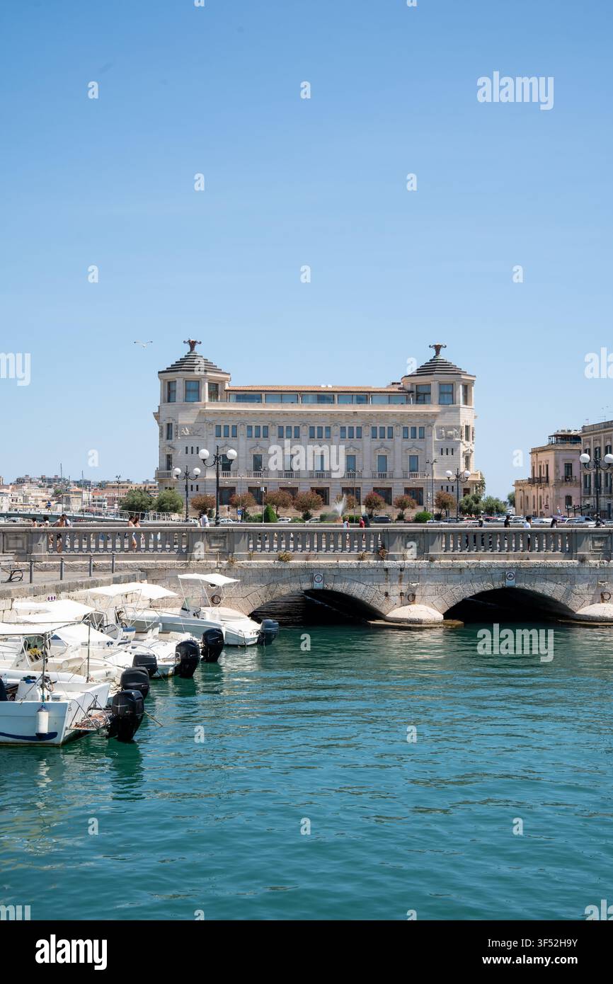 Storico Palazzo delle Poste e porticciolo all'ingresso di Ortigia, Sicilia, ora occupato dall'Hotel Ortea Palace Foto Stock