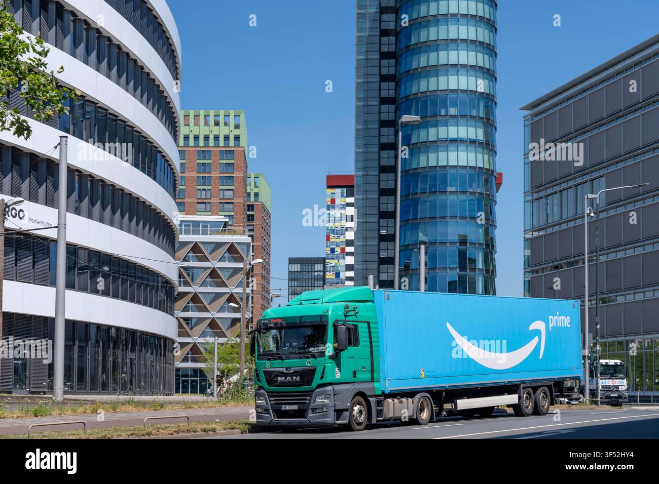 Edifici nel Medienhafen di Düsseldorf, Holzstraße, Speditionstraße, strada di accesso al porto cittadino, camion Amazon Prime, residenze e uffici moderni Foto Stock