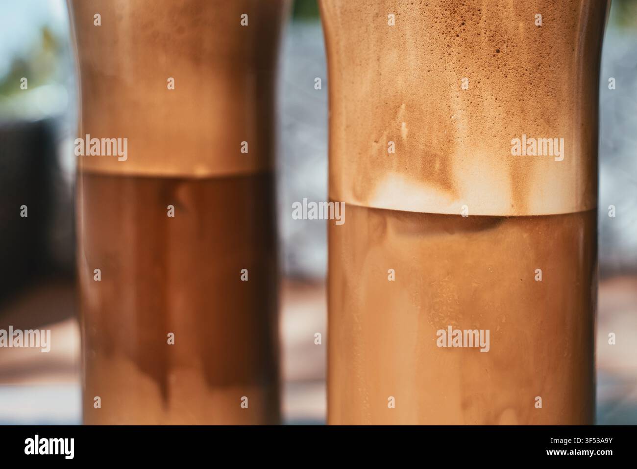 Primo piano di due bicchieri alti pieni di rinfrescanti bevande al caffè ghiacciato schiumose con spessi strati di schiuma in cima, Grecia. Foto Stock