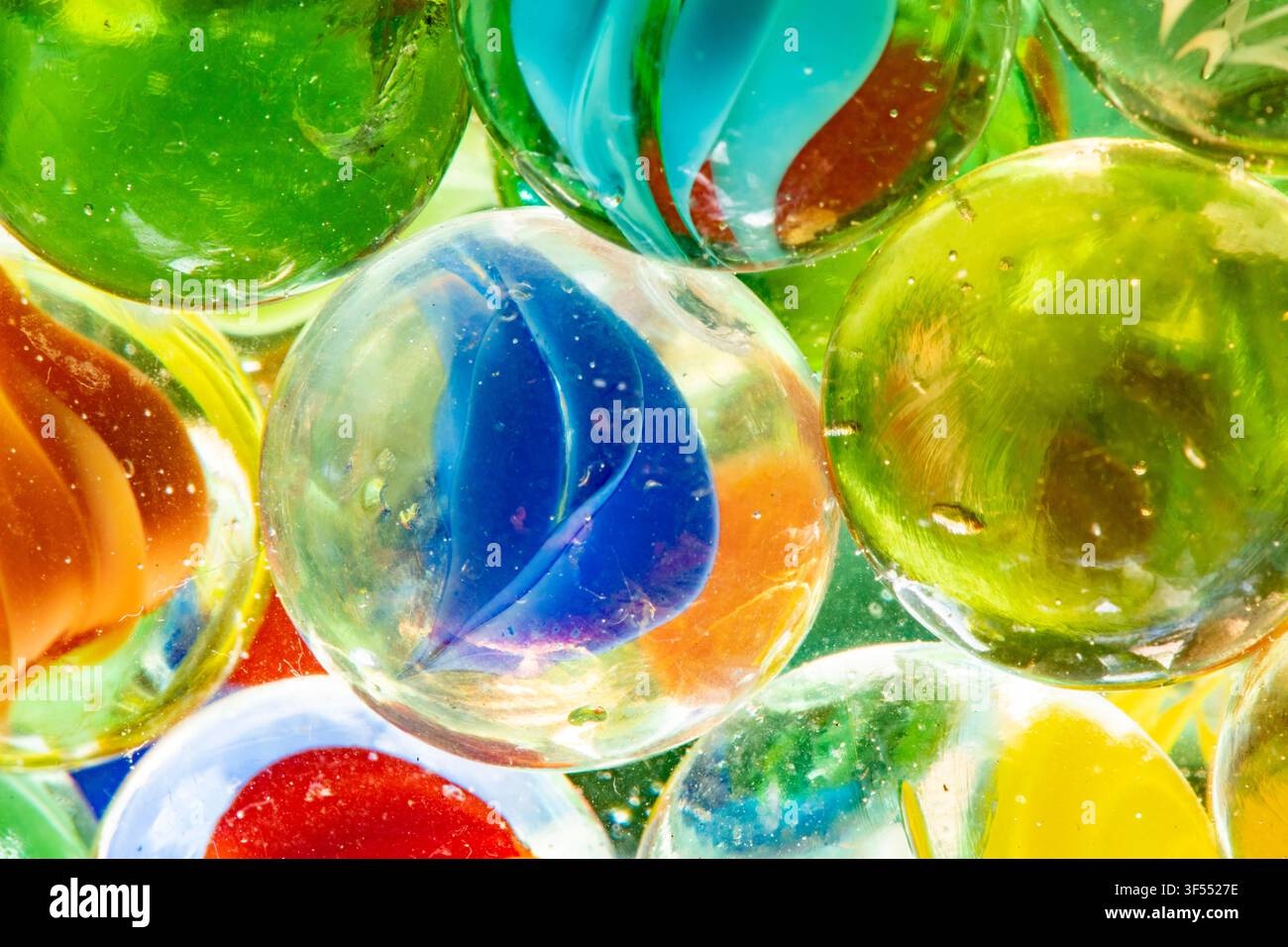 Gruppo di sfere di vetro vibranti che mostrano motivi traslucidi e rifrazioni della luce Foto Stock