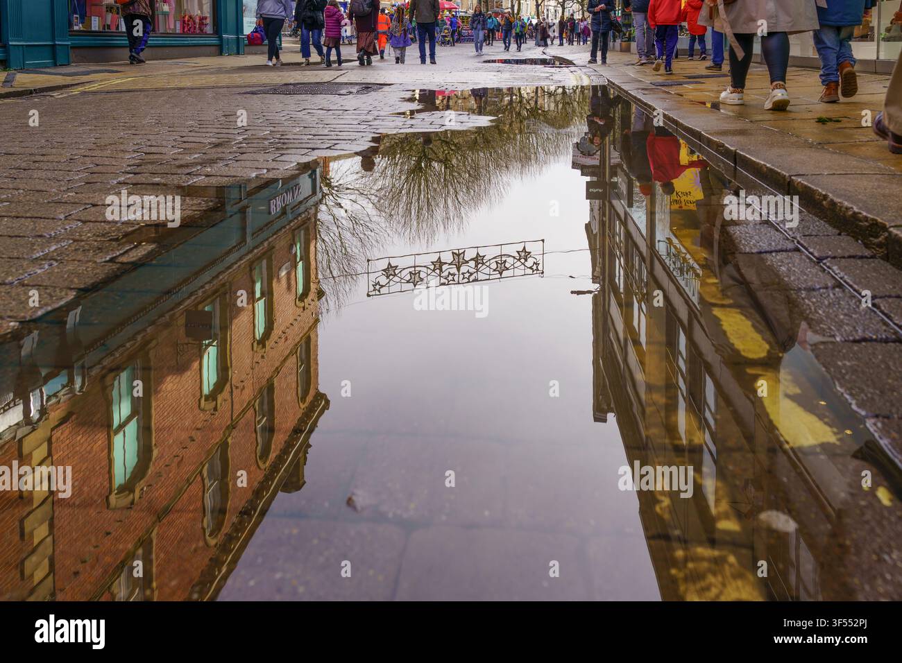 Fotografia creativa a bassa angolazione della strada che cattura riflessi colorati dopo la pioggia nella città storica di York, Inghilterra, Regno Unito Foto Stock
