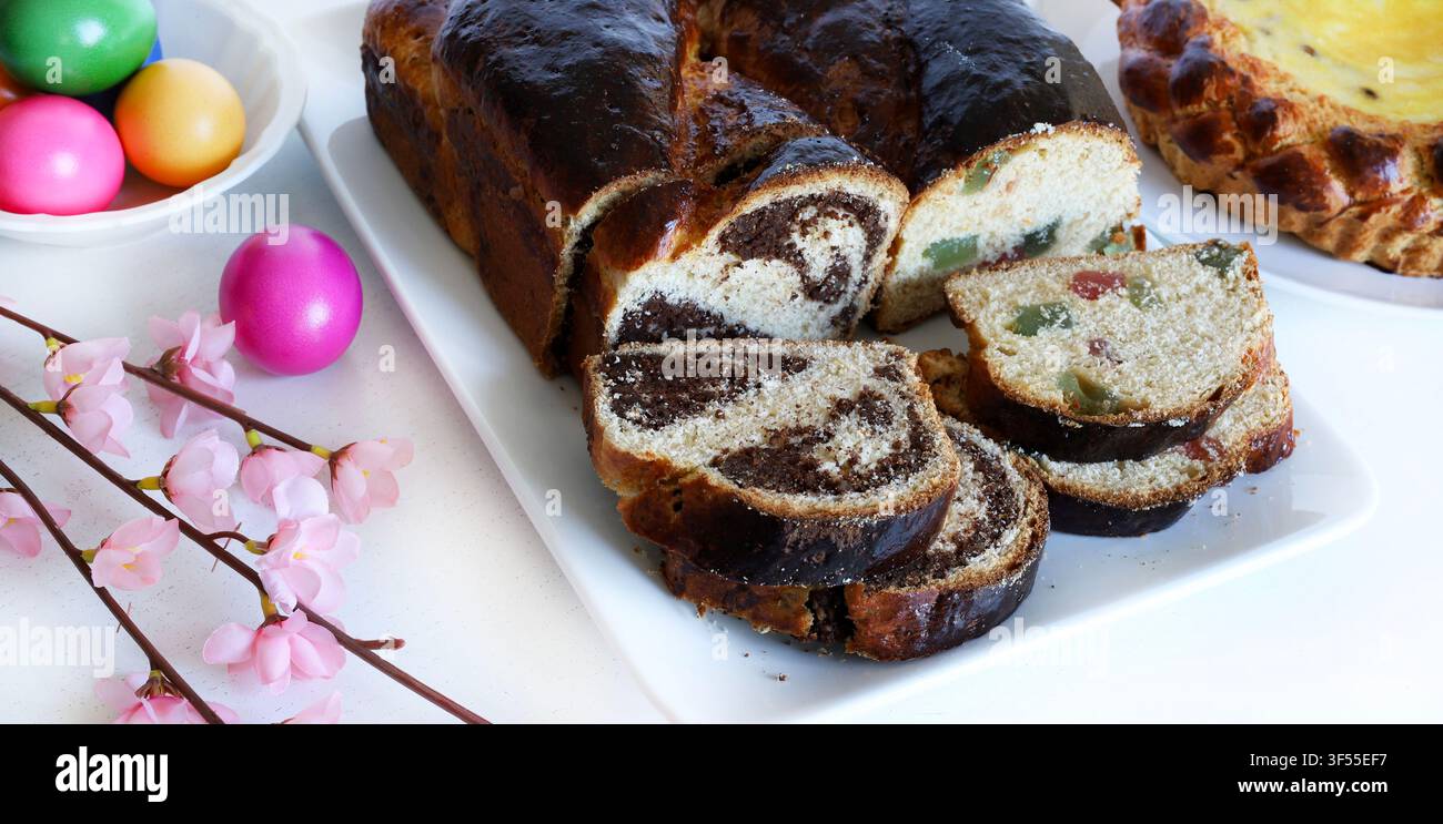 Cozonac rumeno tradizionale con noci, spirale di cacao e Turkish delight. Pane dolce affettato con uova colorate festive. Foto Stock