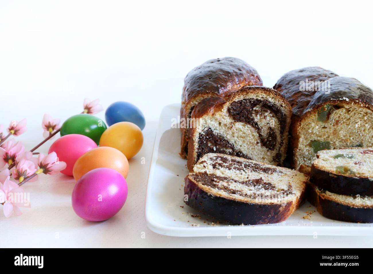Cozonac rumeno tradizionale con noci, spirale di cacao e Turkish delight. Pane dolce affettato con uova colorate festive. Foto Stock