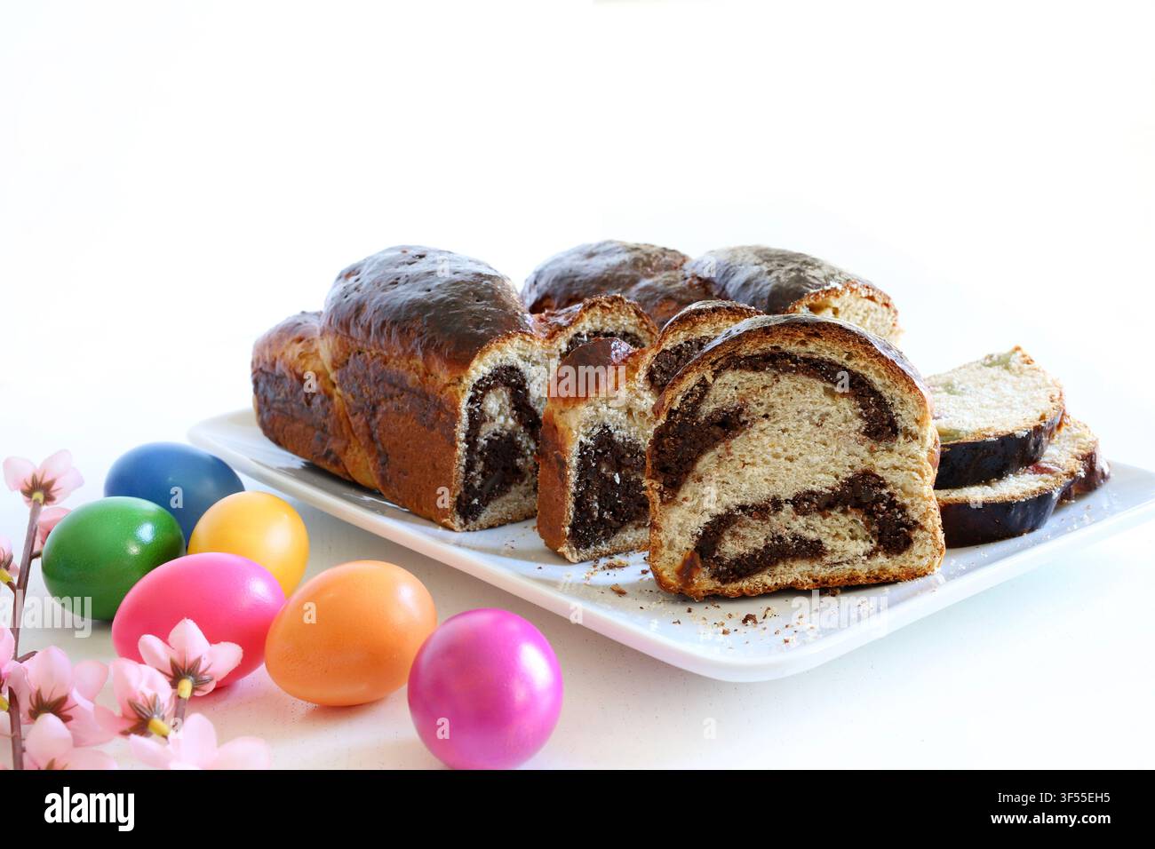 Cozonac rumeno tradizionale con noci, spirale di cacao e Turkish delight. Pane dolce affettato con uova colorate festive. Foto Stock